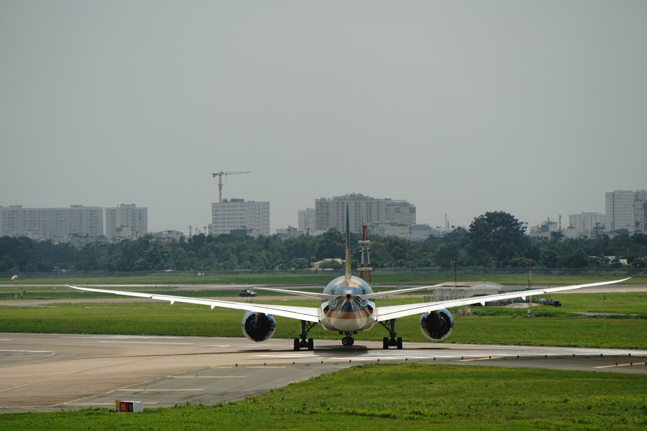 Commercial airplane on the runway with city skyline in the background, ready for takeoff.